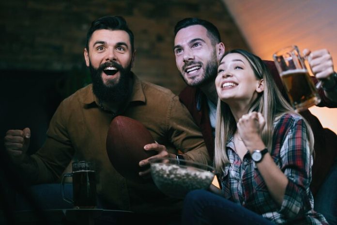 grupo-de-pessoas-alegres-assistindo-jogo-de-rugby-na-tv-e-torcendo-por-seu-time_637285-3350